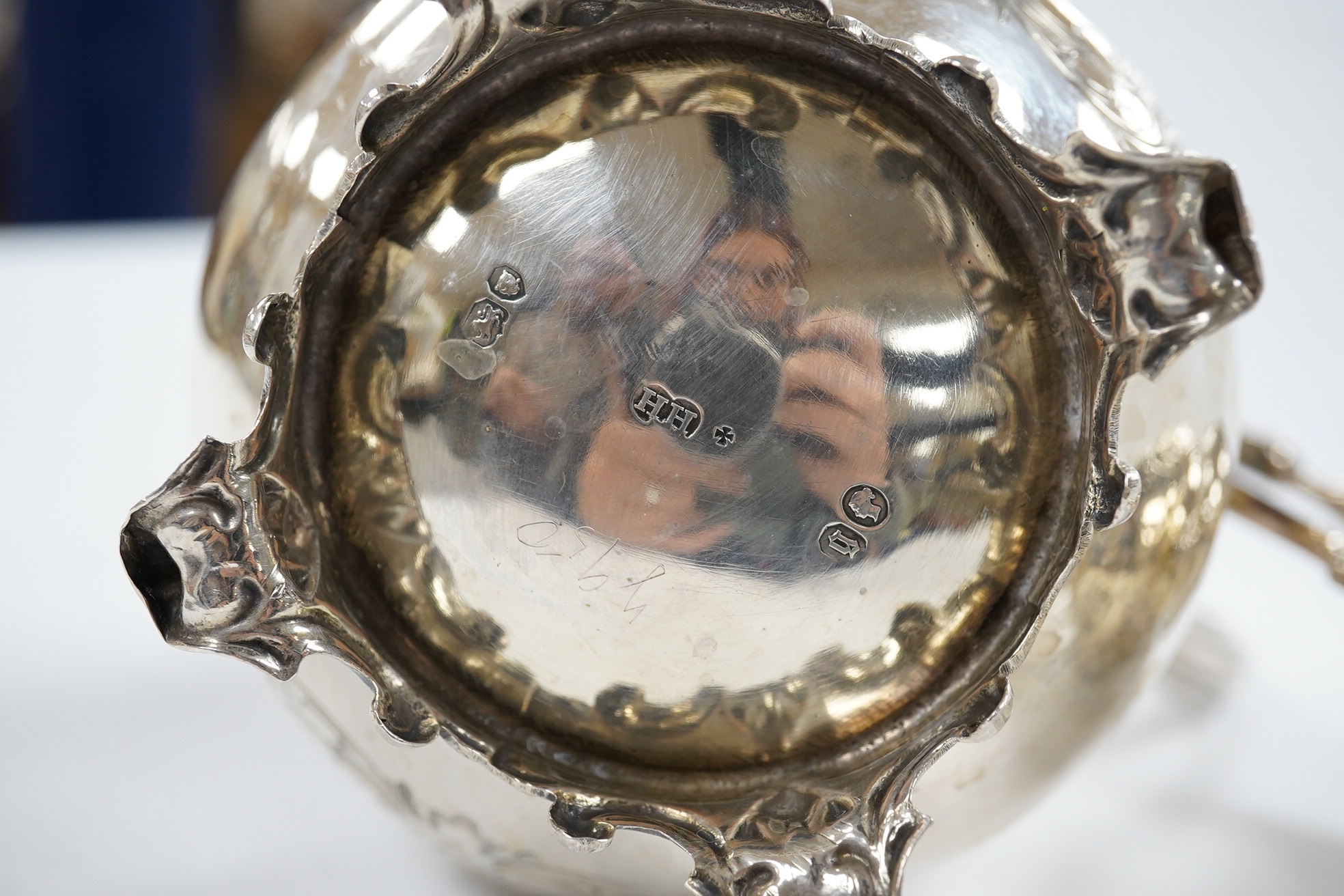 A Victorian engraved silver baluster cream jug, Henry Holland, London, 1862, 15cm, together with an Edwardian embossed silver cream jug, London, 1902, 10.5oz. Condition - poor